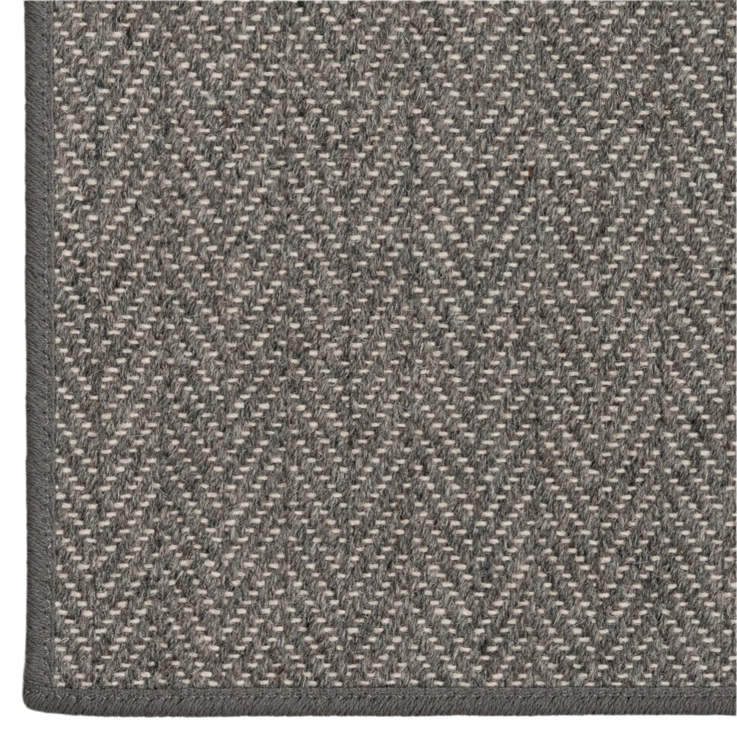 Close-up of a gray and beige herringbone patterned rug.