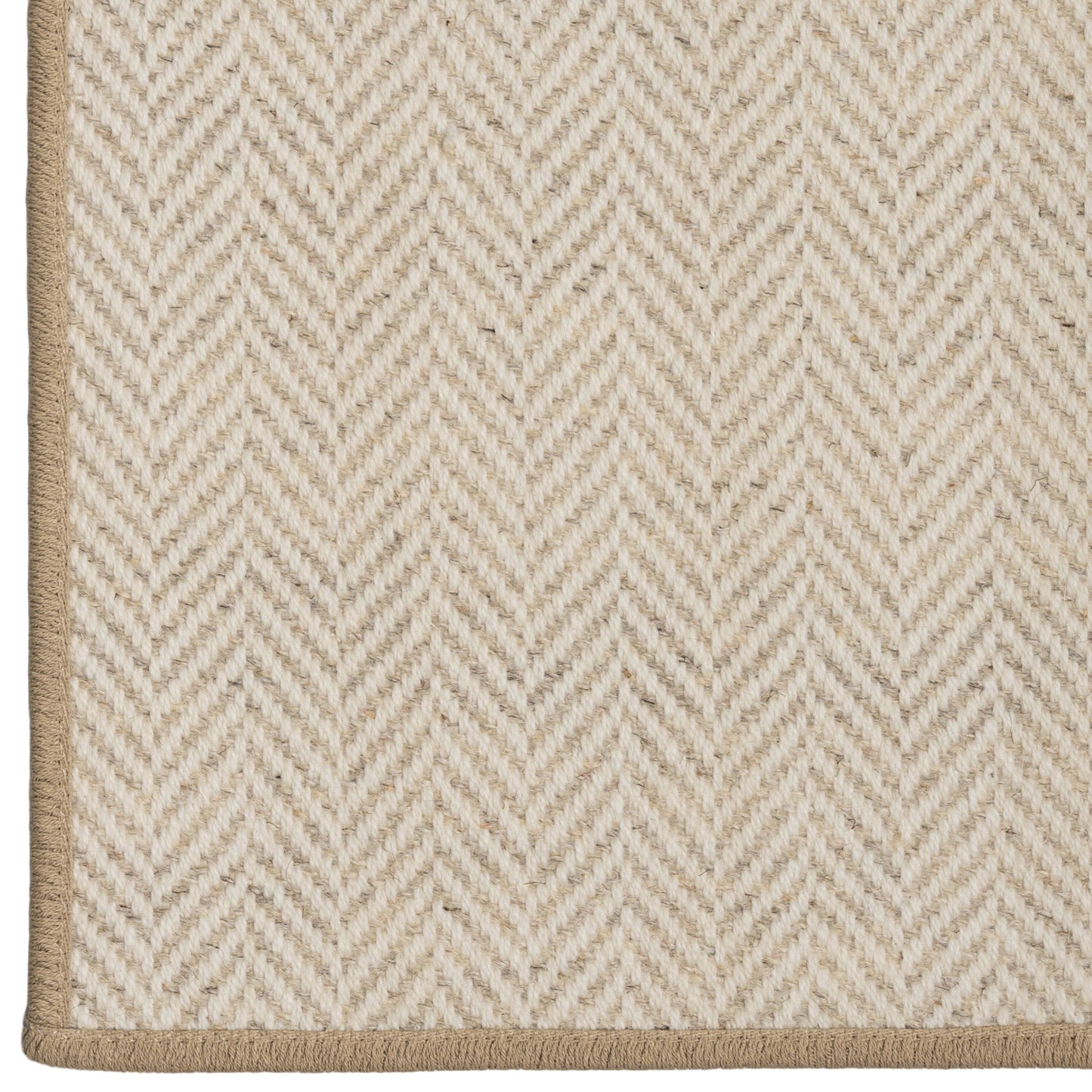 Close-up of a beige and white herringbone patterned rug.