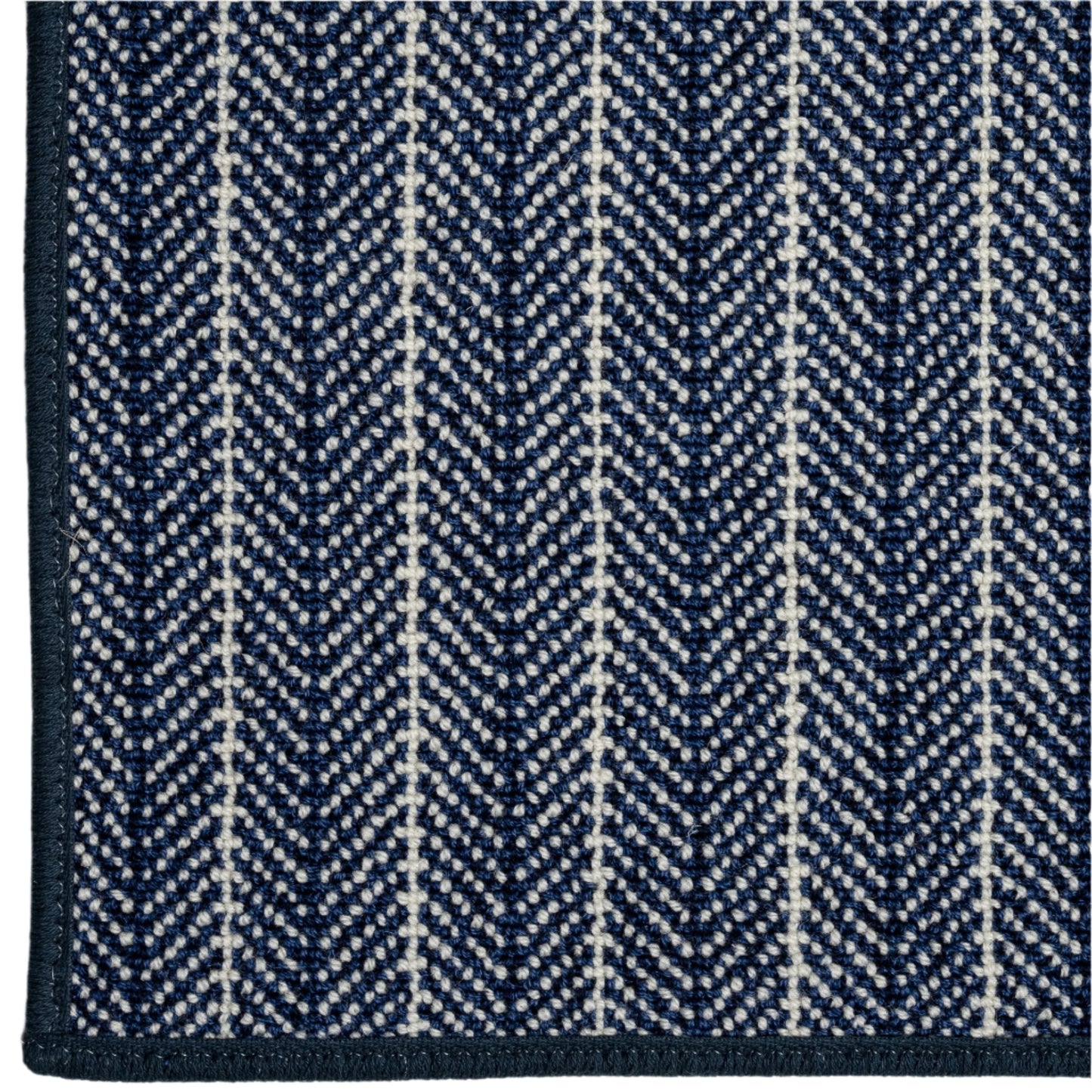 Close-up of a blue and white herringbone patterned rug.