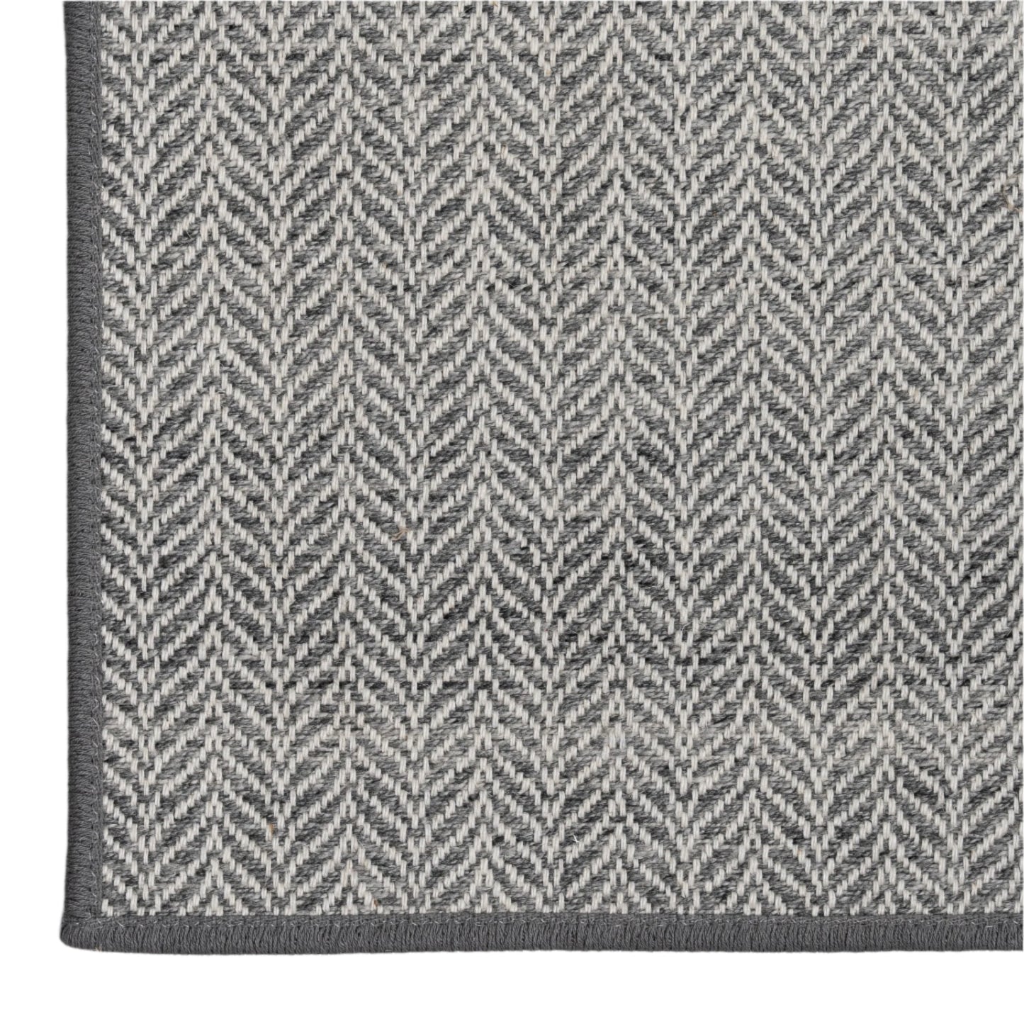 Gray and white herringbone patterned rug on a light gray background