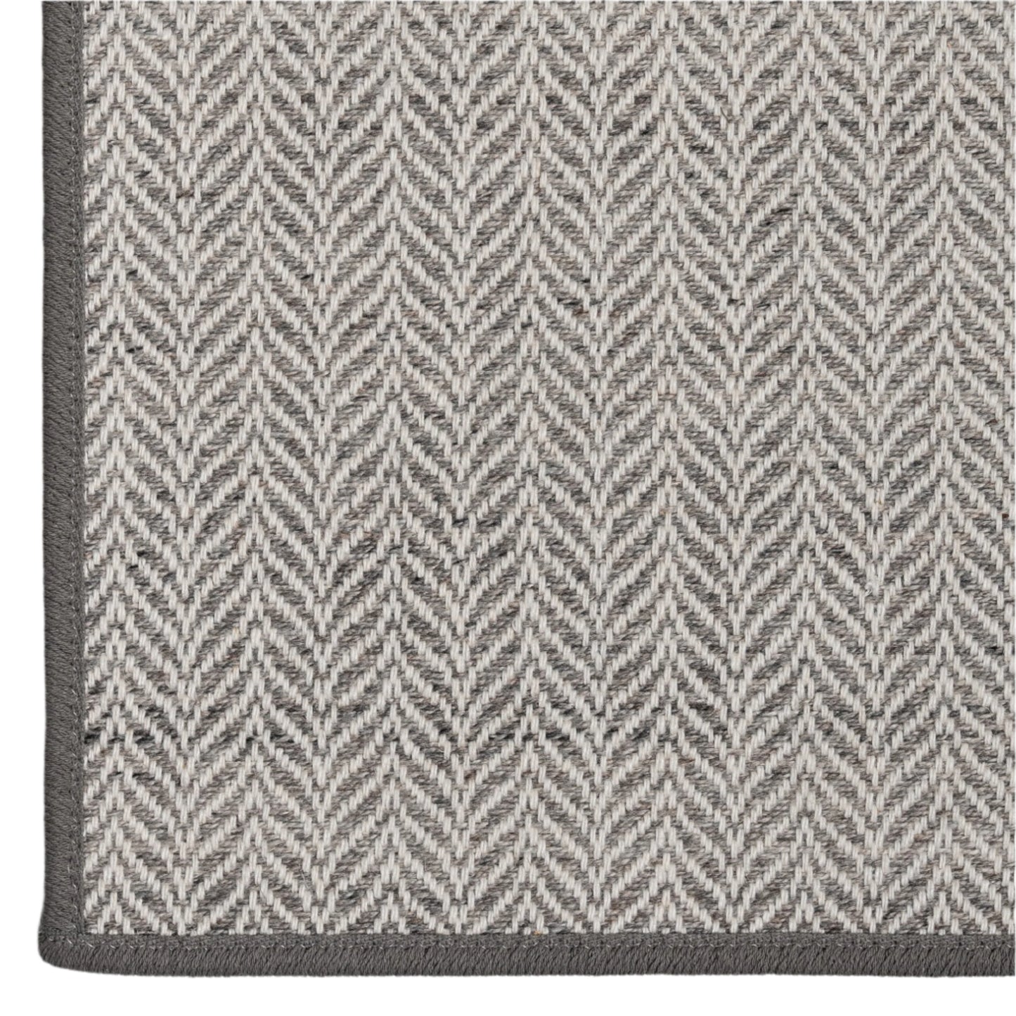 Close-up of a gray and white herringbone patterned rug.