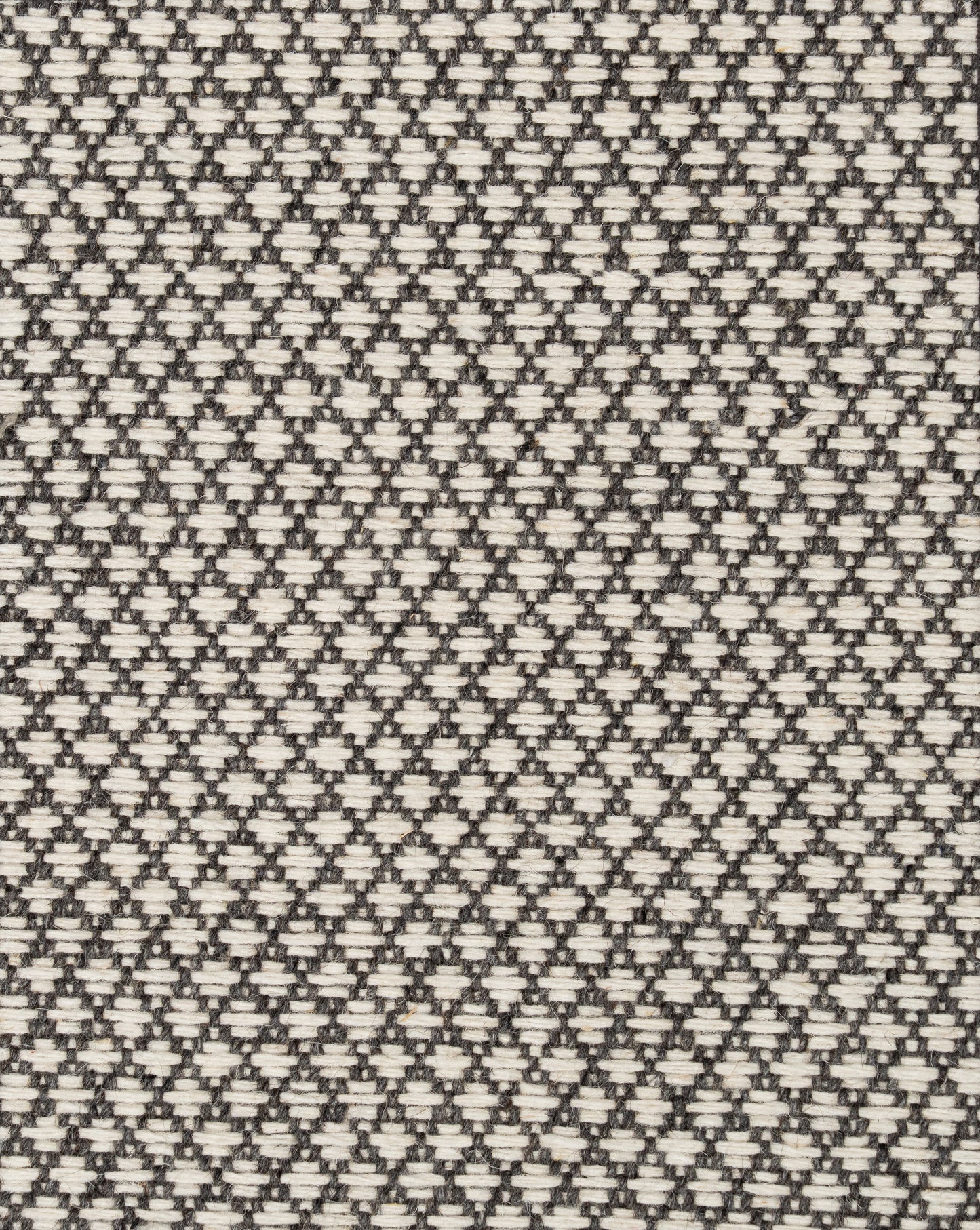 A hand-loomed black nd white geometric wool carpet with a small-scale diamond pattern that looks gorgeous as living room carpet, bedroom carpet, or on stair.