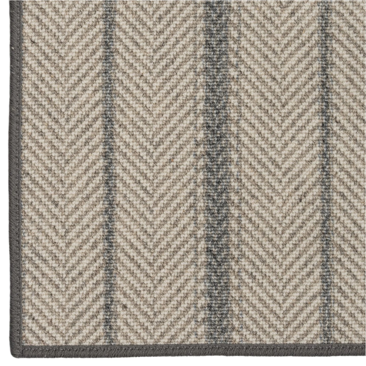 Close-up of a herringbone patterned rug with alternating dark and light stripes.