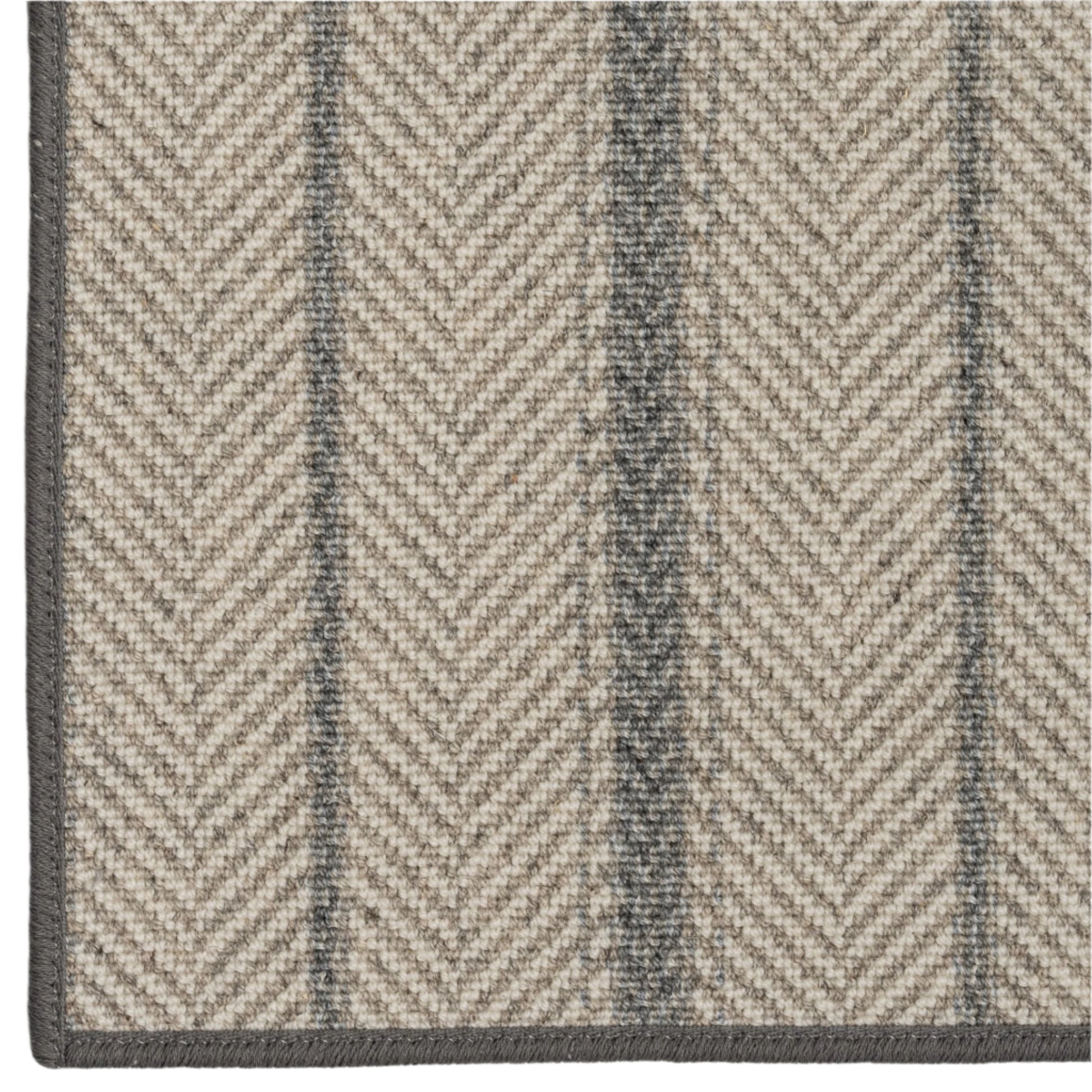 Close-up of a herringbone patterned rug with alternating dark and light stripes.