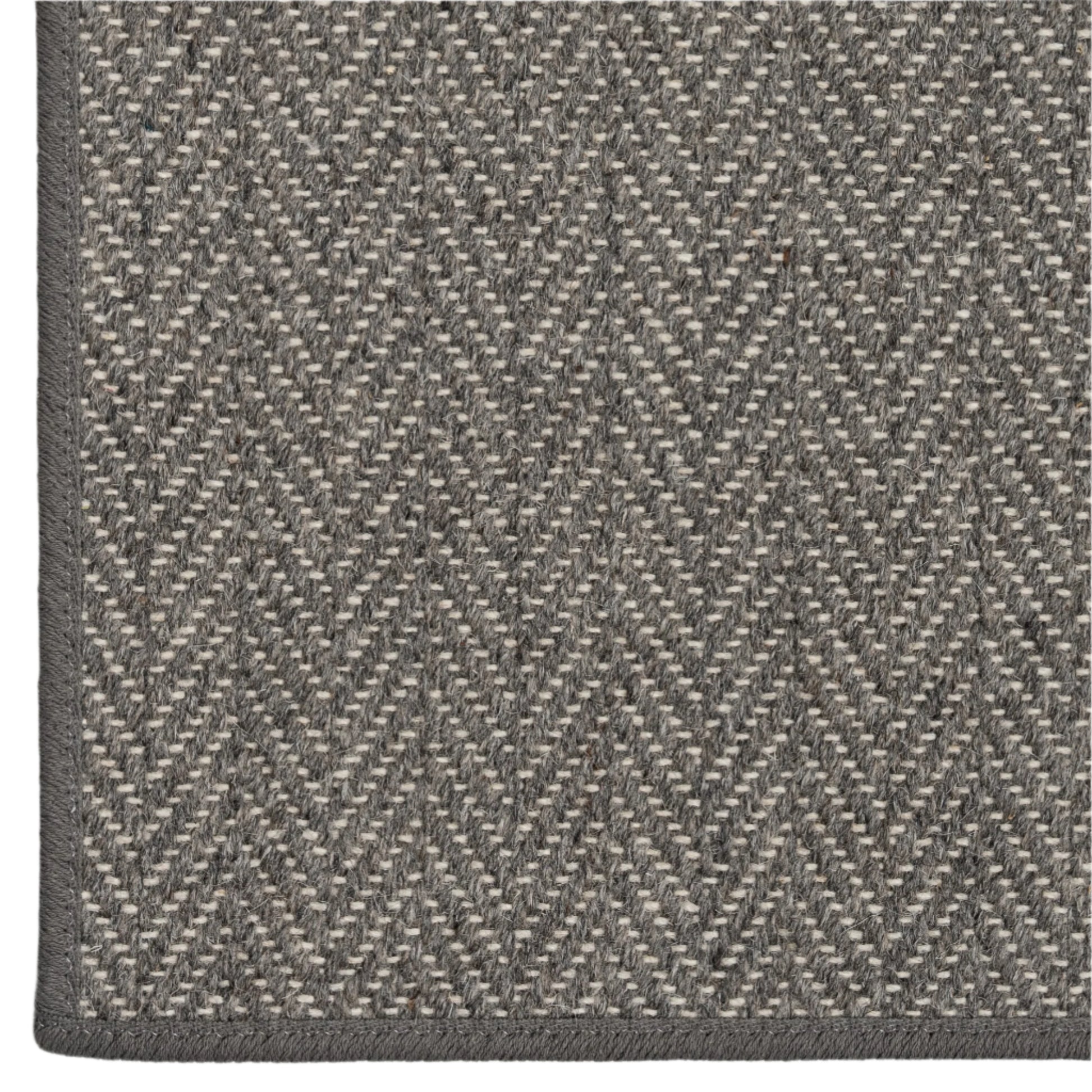 Close-up of a gray and beige herringbone patterned rug.