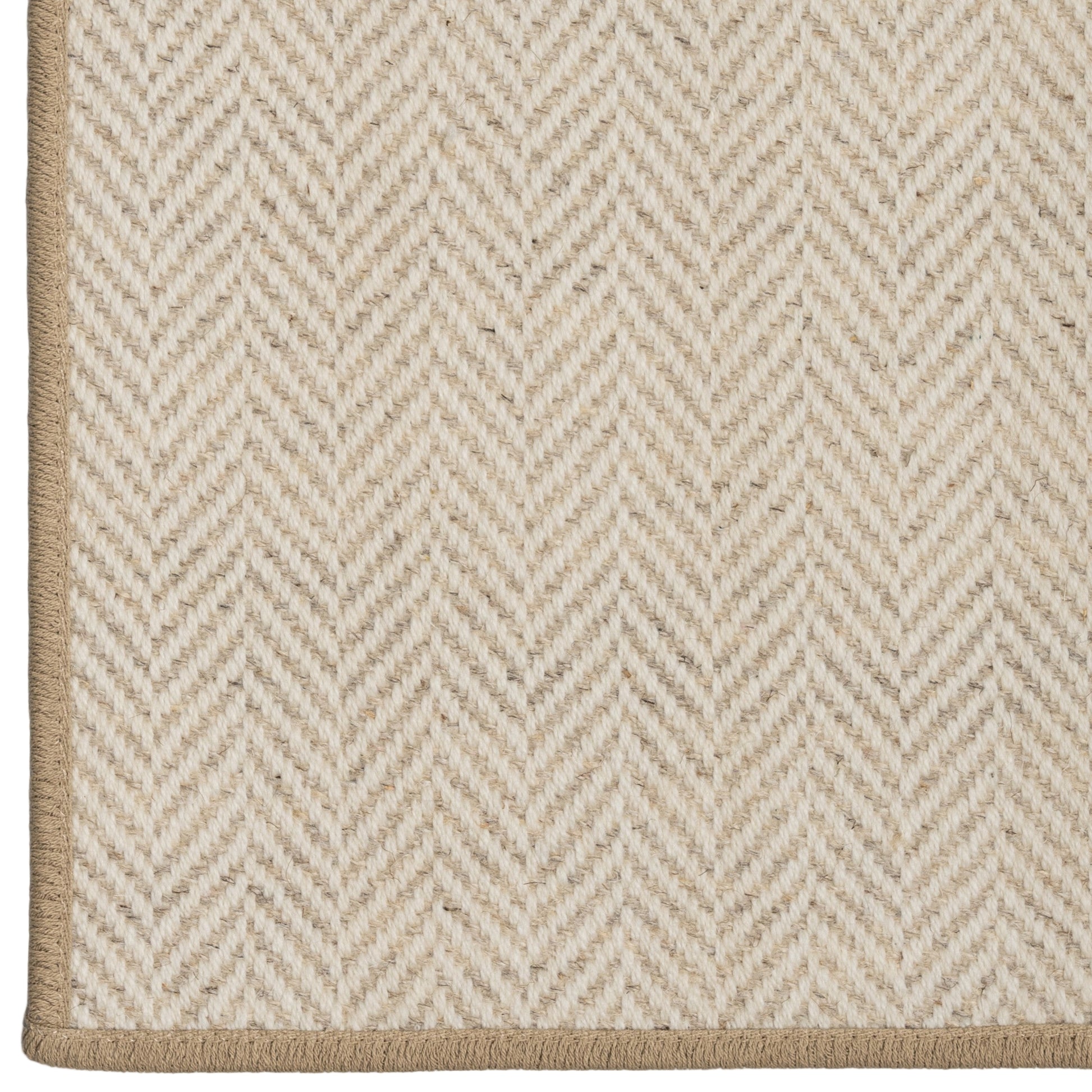 Close-up of a beige and white herringbone patterned rug.
