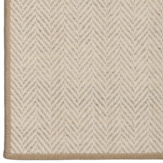 Close-up of a beige and white herringbone patterned rug.