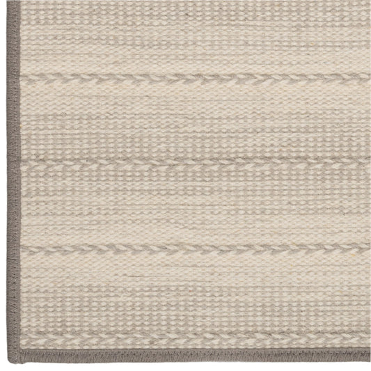 Close-up of a textured rug with horizontal stripes on a neutral background