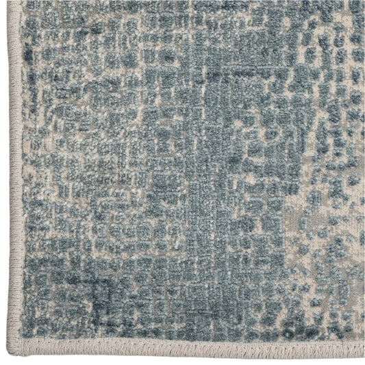 Close-up of a textured blue and beige area rug with a geometric pattern.