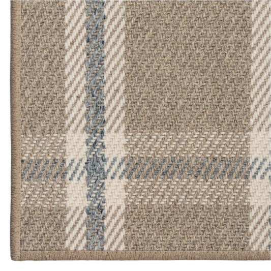 Close-up of a textured fabric with plaid pattern in beige and blue.