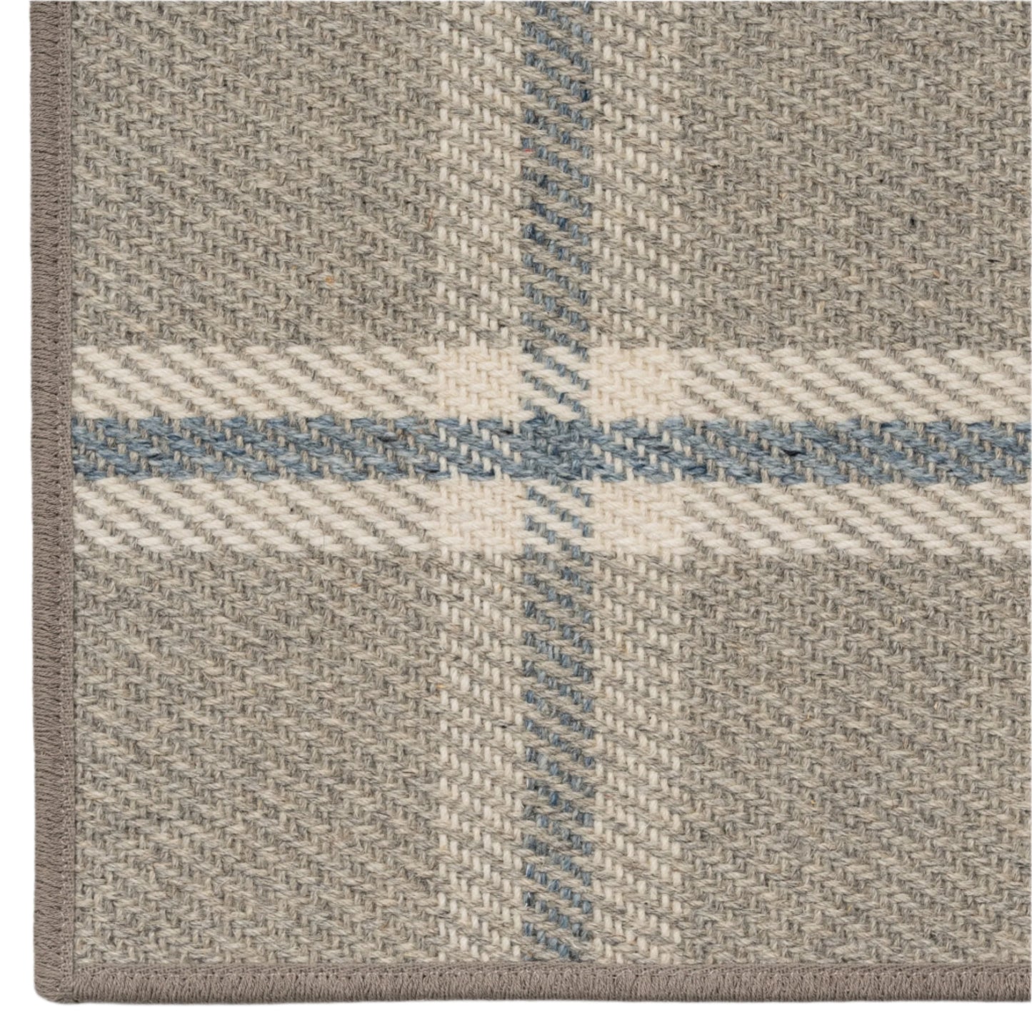 Close-up of a plaid patterned rug with beige, blue, and white colors.
