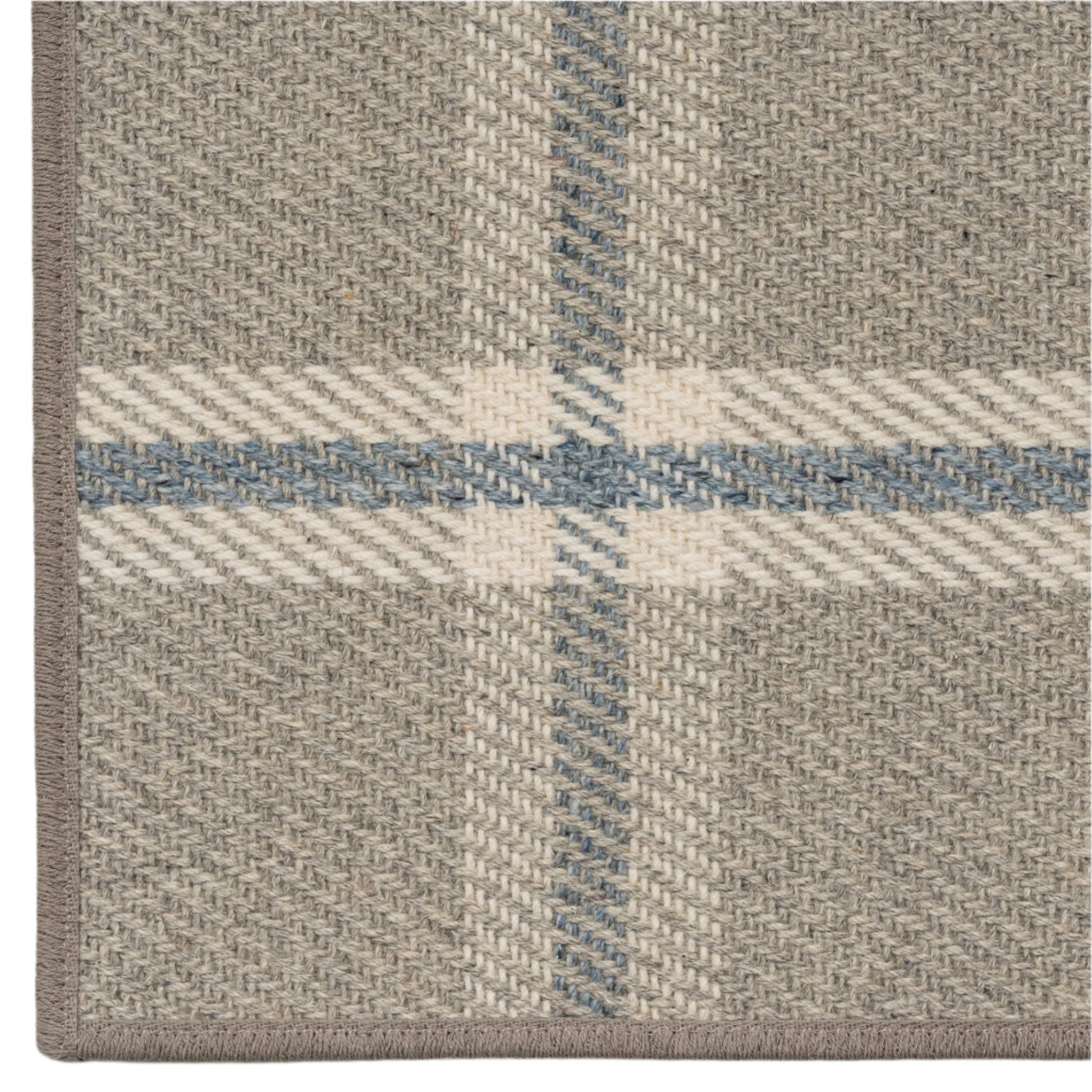 Close-up of a plaid patterned rug with beige, blue, and white colors.