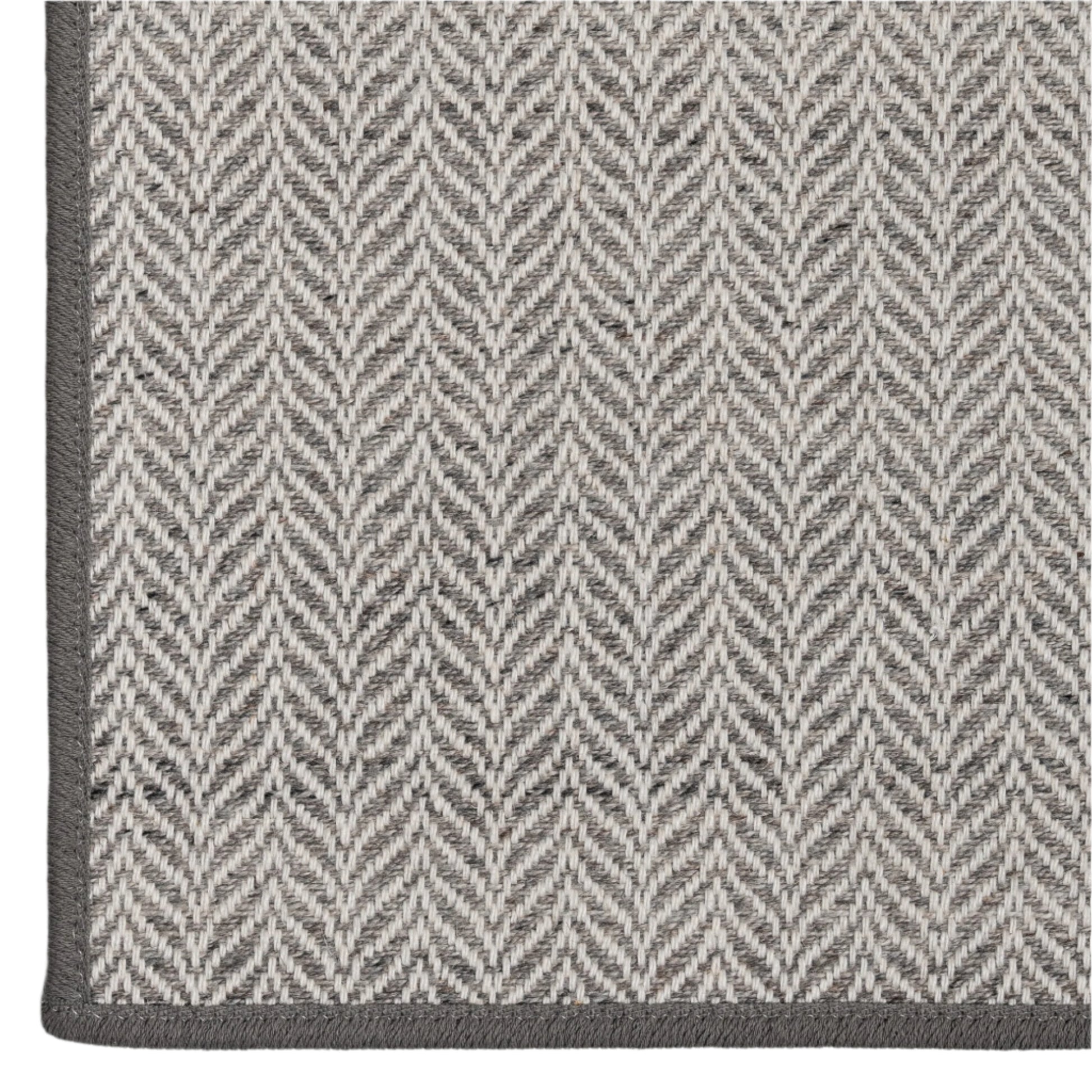 Close-up of a gray and white herringbone patterned rug.
