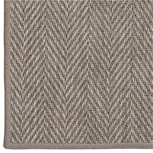 Close-up of a textured fabric with a herringbone pattern in neutral colors.