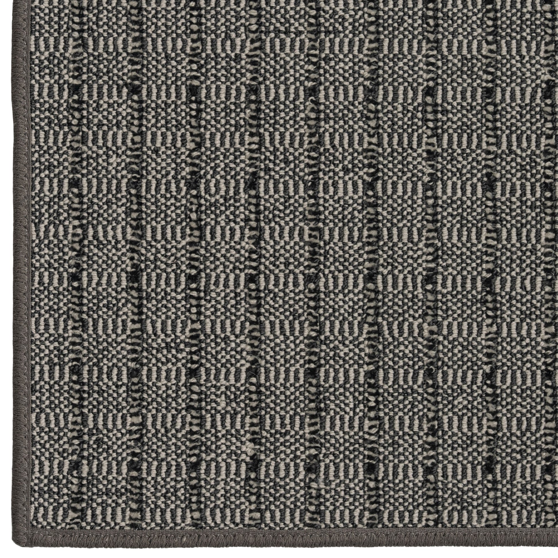 Close-up of a textured gray rug with a geometric pattern