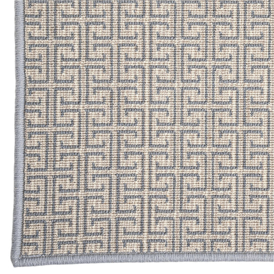 Close-up of a textured rug with a geometric pattern on a plain background
